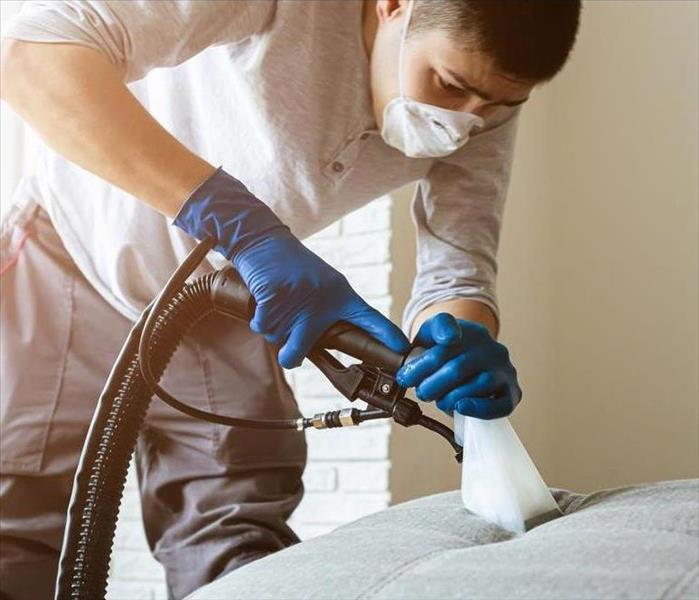 Man cleaning sofa chemical cleaning with professionally extraction method.